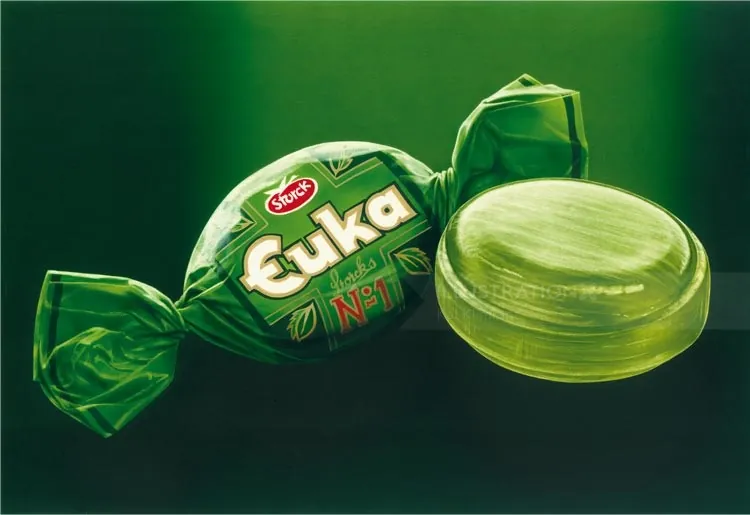 Green wrapped candy and unwrapped green sweet by Kai Klimiont