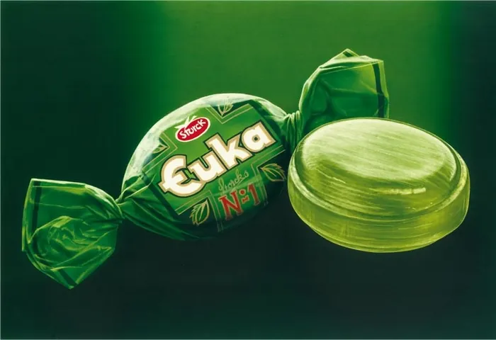 Green wrapped candy and unwrapped green sweet by Kai Klimiont