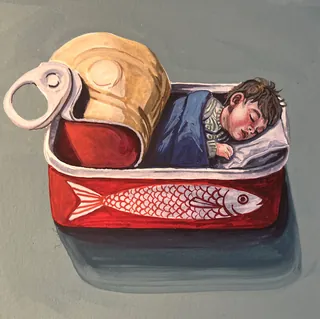 Child sleeping inside an open red sardine can with a fish design.