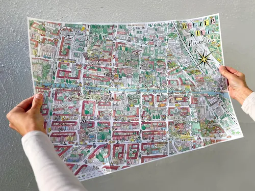 Carte de ville illustrée et colorée tenue par deux personnes, œuvre de Katherine Kannon
