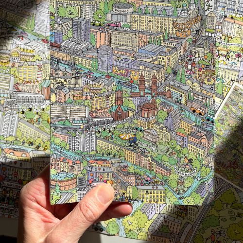 Katherine Kannon's colorful illustrated city map held in a person's hand