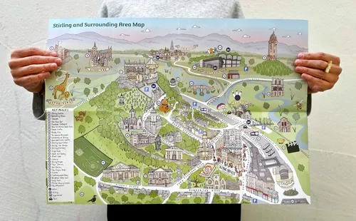 Katherine Kannon tient une carte illustrée d'une ville et de la campagne environnante.