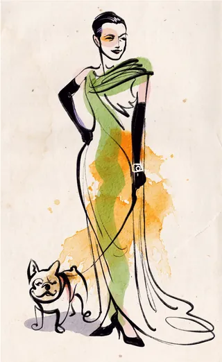 Stylish woman in a long dress walking a small dog on a leash.