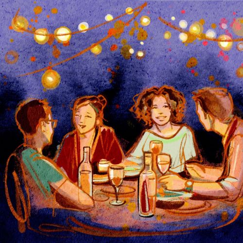 Four people enjoying a summer dinner party under string lights