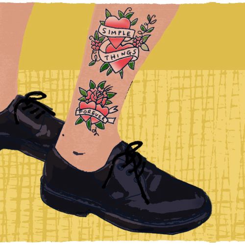 Leg with tattoos and black shoes by Kavel Rafferty