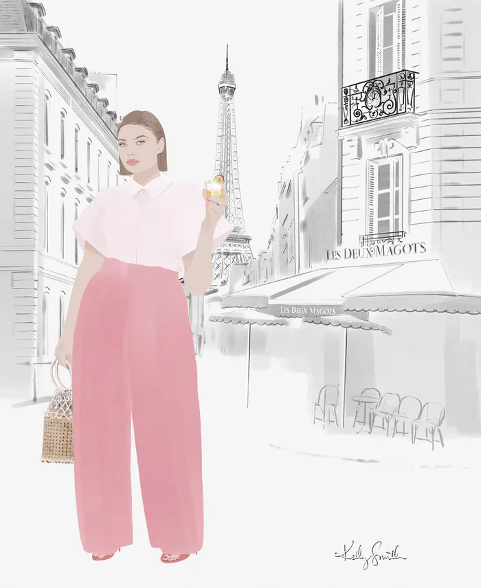 Woman in pink pants holding a cocktail near the Eiffel Tower in Paris