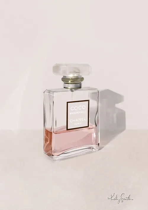 Coco Mademoiselle perfume bottle with pink liquid on light surface