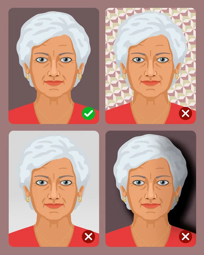 Elderly woman with white hair wearing red top on plain background