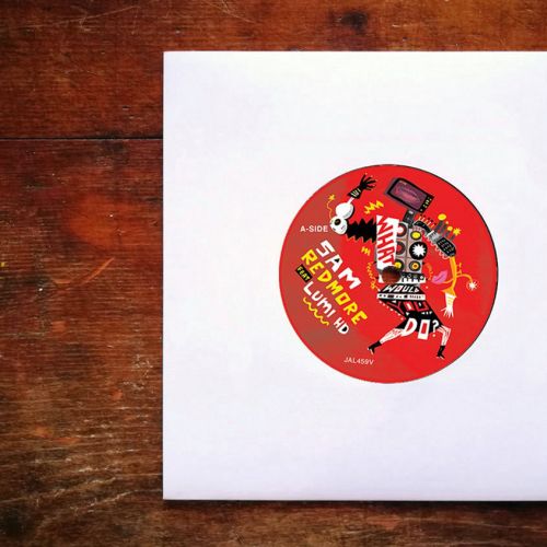 Vinyl record with red label on wooden surface in white sleeve