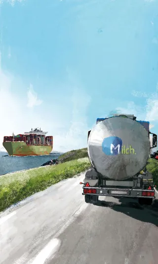 Milk tanker truck on a countryside road under clear blue sky