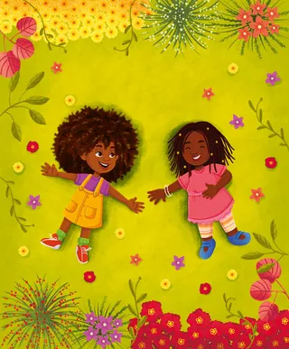 Two happy children lying on green grass with flowers around