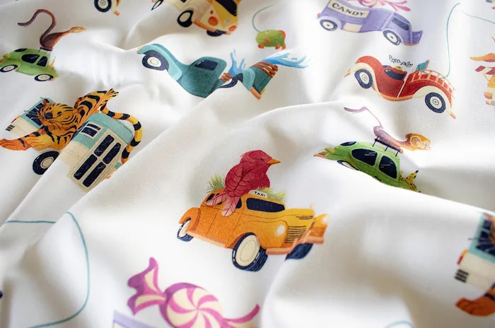 White fabric featuring colorful vintage cars and animals pattern