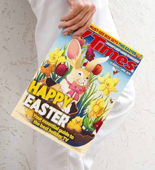 Hand holding Easter magazine featuring bunny and colorful spring flowers