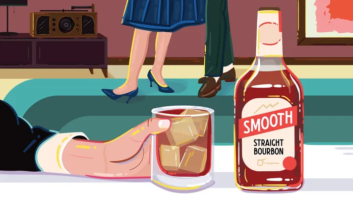 Hand holding bourbon glass next to smooth straight bourbon bottle by Mallory Heyer