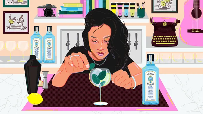 Woman making cocktail at bar with Bombay Sapphire bottles by Mallory Heyer