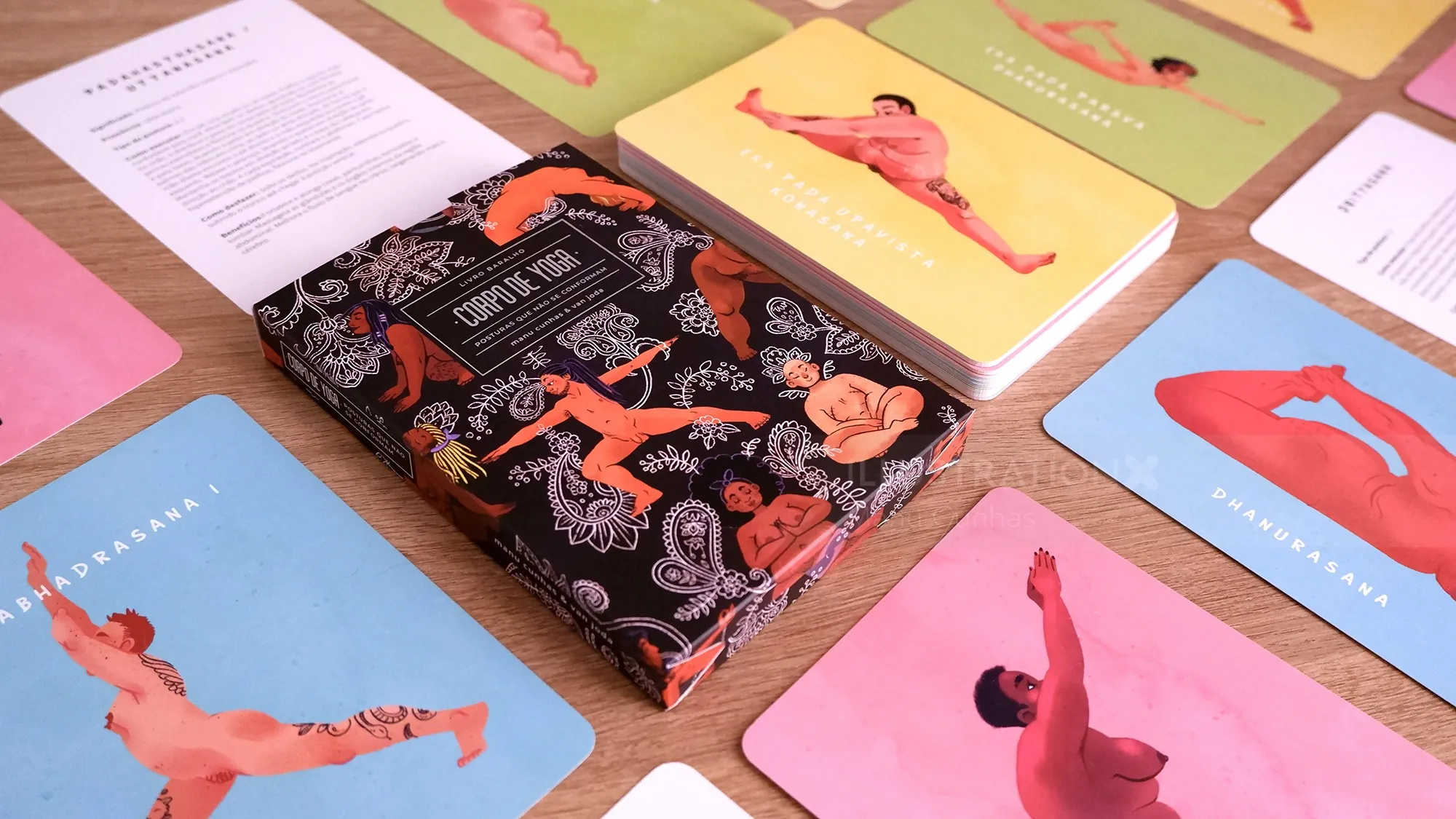 Illustrated figure cards and book by Manu Cunhas on a colorful table