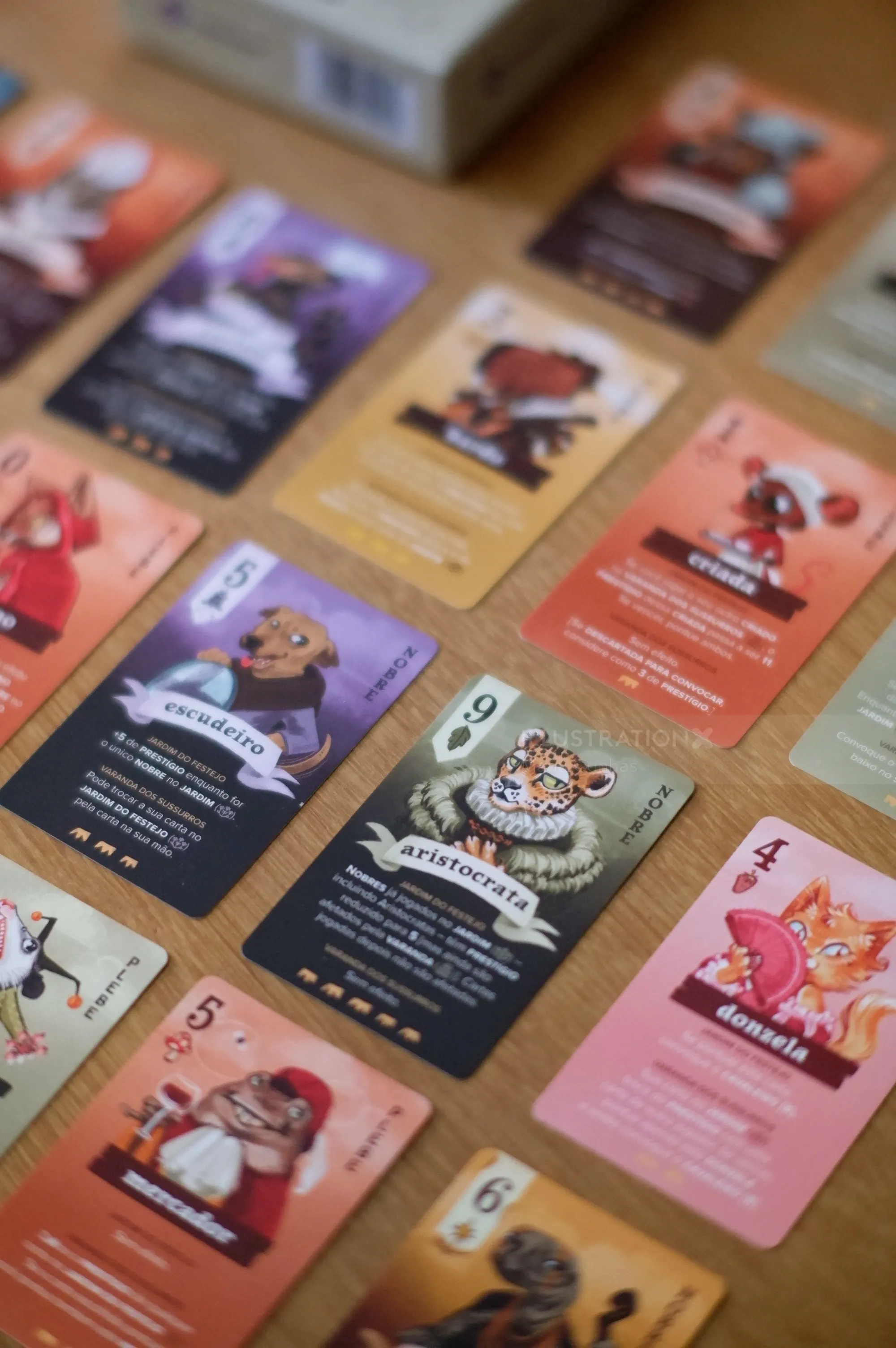 Illustrated character cards by Manu Cunhas arranged on a wooden table