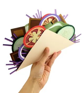 Paper taco filled with paper vegetables held by hand, artwork by Martha von Maydell