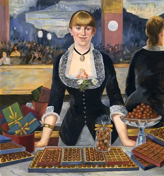 Woman in black dress standing behind table with chocolates and gifts