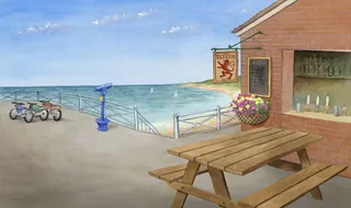 Picnic table and stone building by the ocean with binoculars and sailboats.
