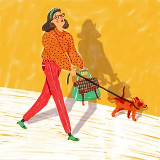 Woman in polka dot shirt walking a small dog with leash