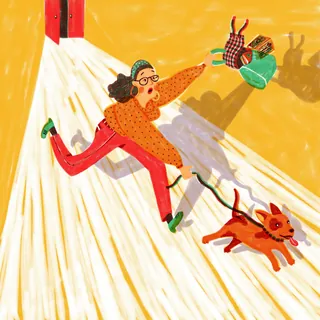 Person running after a dog holding a bag in its mouth.