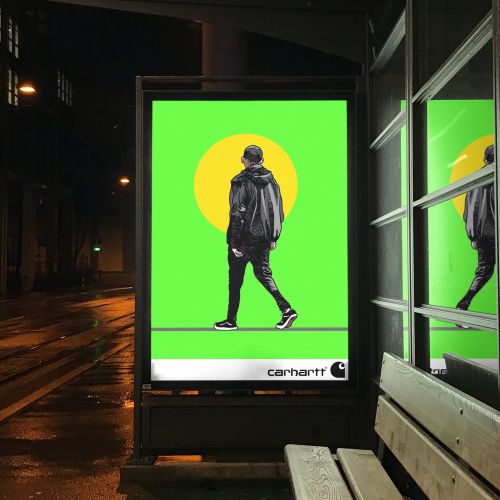Person walking shown in bright bus stop advertisement at night