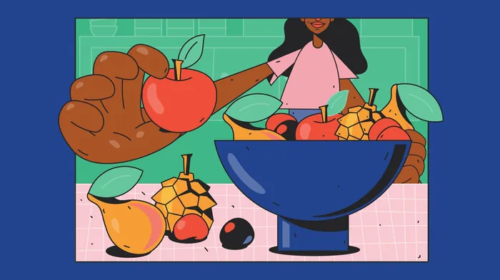 Person holding apple next to bowl of various fruits on table