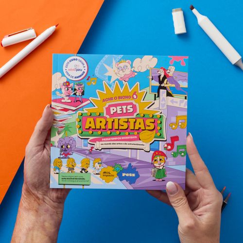 Person holding Pets Artists board game box with colorful design