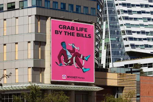 Outdoor billboard with Rocket Money ad saying Grab Life by the Bills by Max Erwin