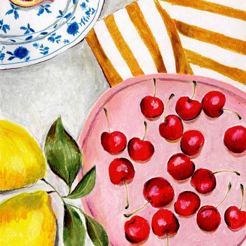 Red cherries on a pink plate with figs and lemons nearby