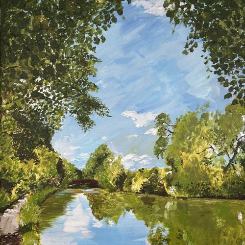 Calm river surrounded by green trees reflecting blue sky and clouds