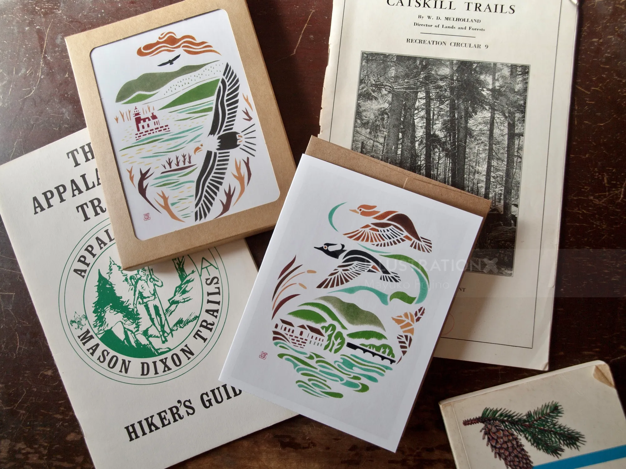 Greeting cards and hiking guidebooks arranged on a wooden surface