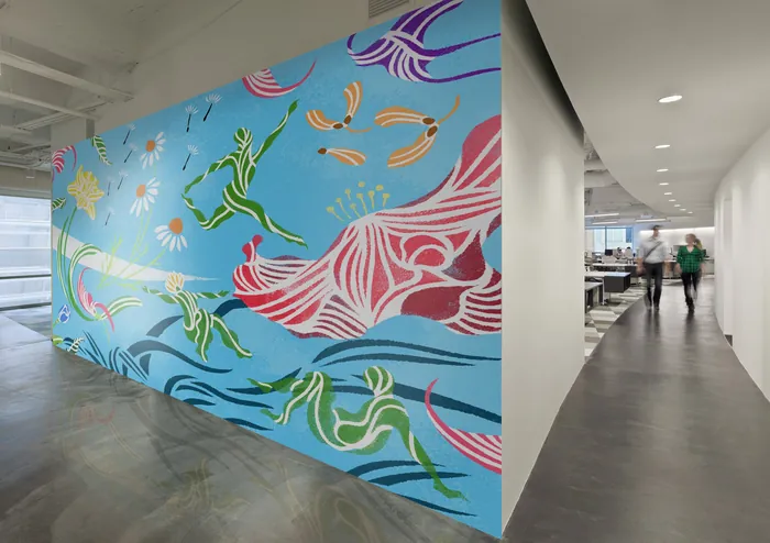 Colorful mural with abstract leafy shapes and organic forms on blue wall