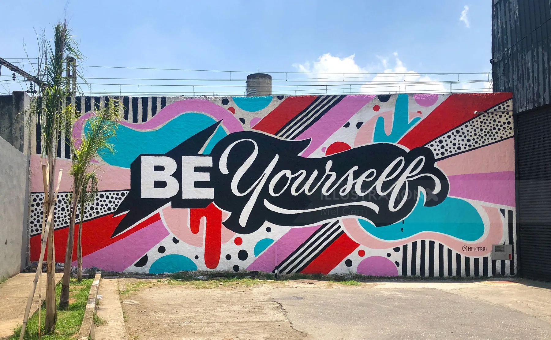 Mural de grafite colorido com o texto "Seja você mesmo" de Mel Cerri