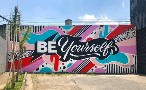 Colorful graffiti mural with text 'Be Yourself' by Mel Cerri