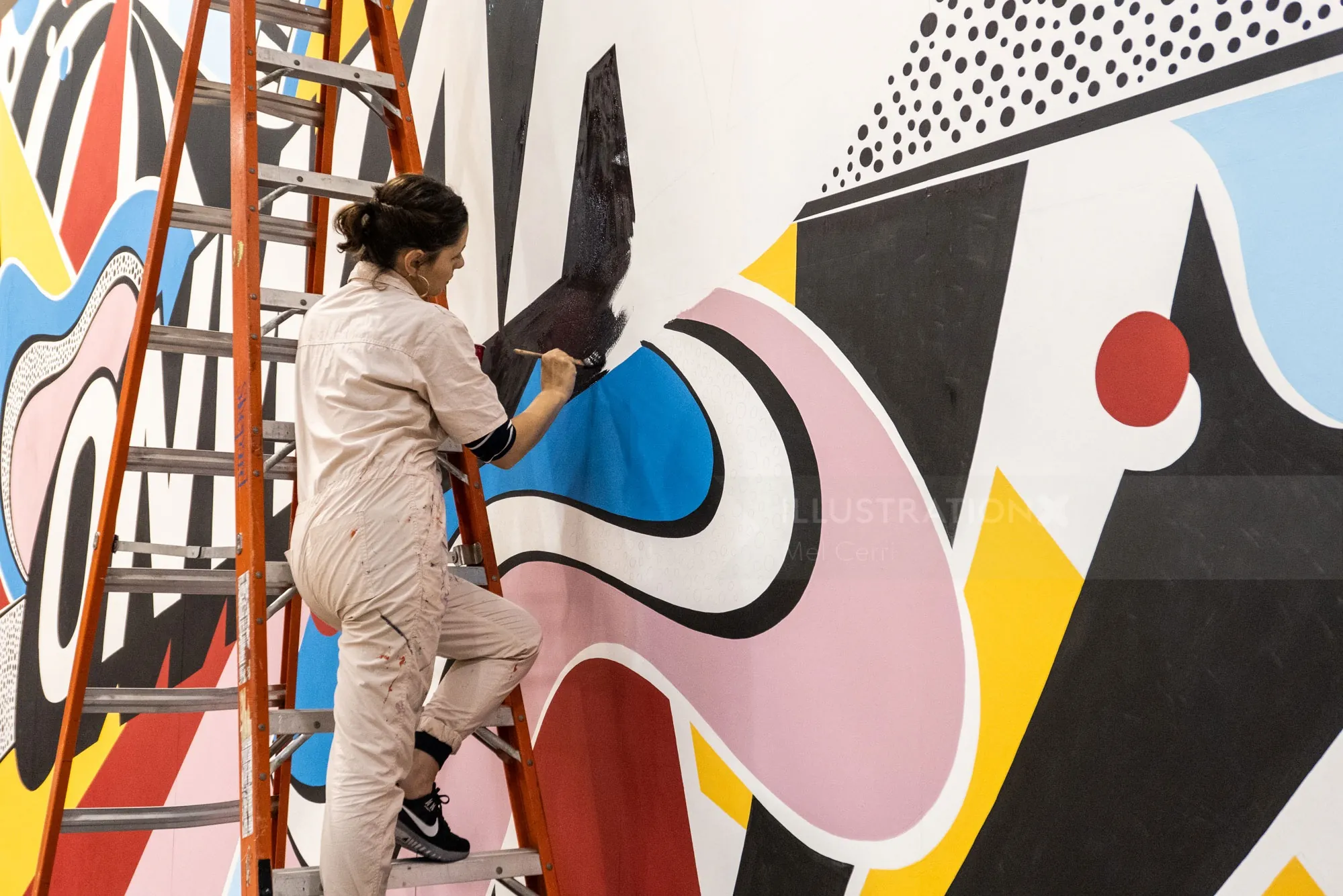 La artista Mel Cerri pinta un mural colorido en vivo en el evento de Keller Williams