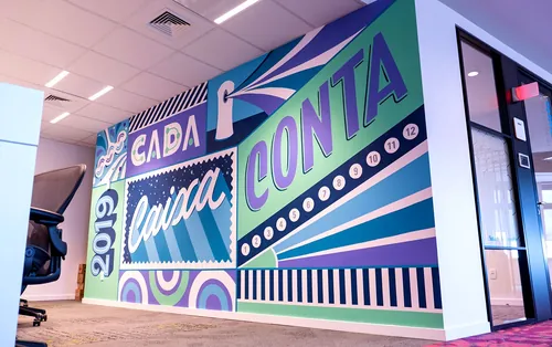 Colorful motivational office mural by Mel Cerri with bold text and shapes