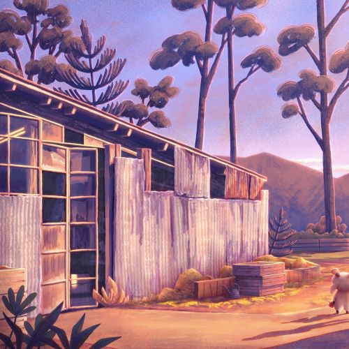 Person walking dog near rustic barn in warm sunset light