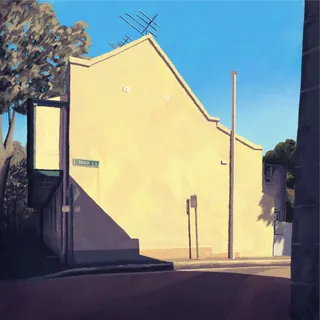 Sunny urban street corner with shadowed building and clear sky