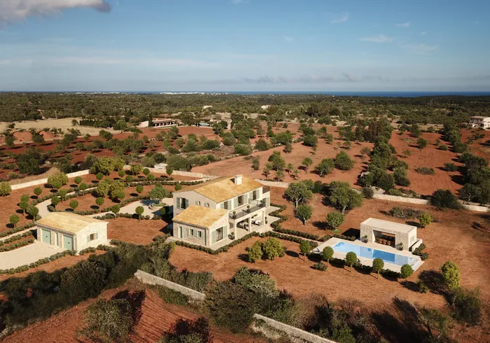 Aerial view of villa with swimming pool in dry landscape by Oliver Hasselluhn