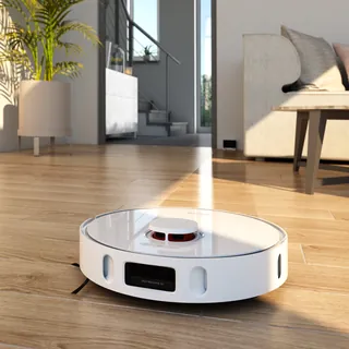 White robot vacuum cleaner on hardwood floor in living room by Oliver Hasselluhn