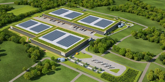 Aerial view of warehouse complex with solar panels and surrounding greenery by Oliver Hasselluhn