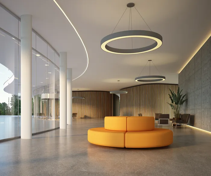 Spacious modern lobby with round orange sofa and circular pendant lights