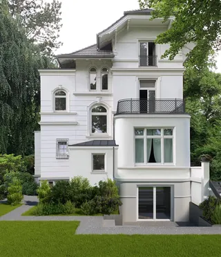 White multi-story house with large windows and green trees around