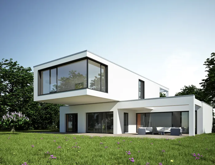 Modern white two-story house with large glass windows and outdoor seating