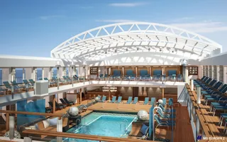 Indoor pool with lounge chairs and wooden deck on cruise ship by Oliver Hasselluhn