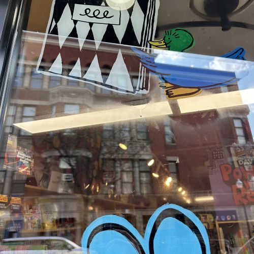 Indie Bookstore Day window mural featuring cartoon character by Ollie Wootton