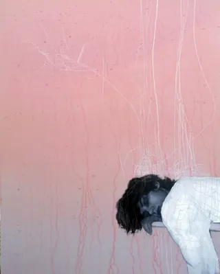 Person resting head on pink textured wall