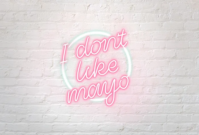 Neon sign 'I dont like mayo' on white brick wall by Peggy Dean